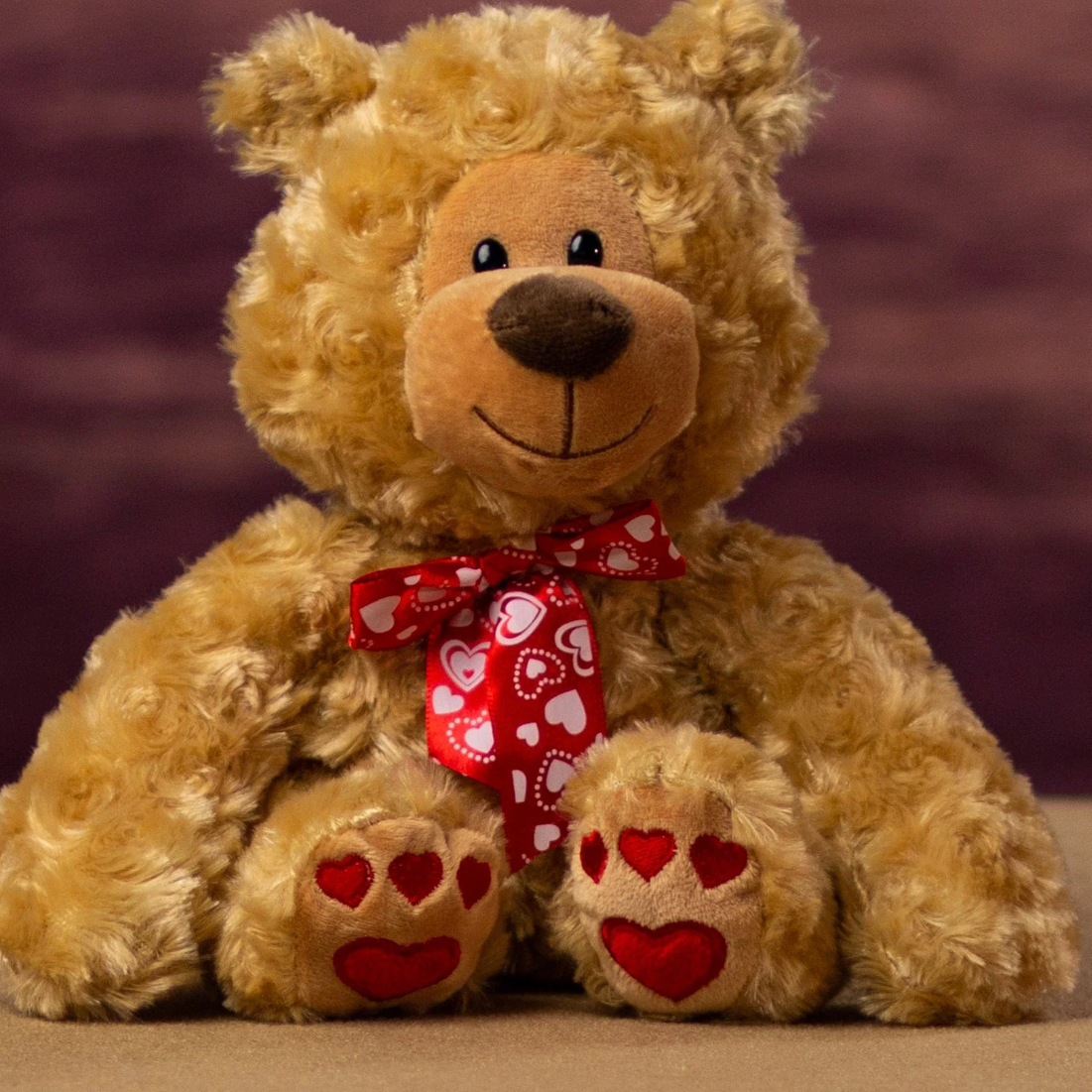 Plush teddy bear with a red heart ribbon