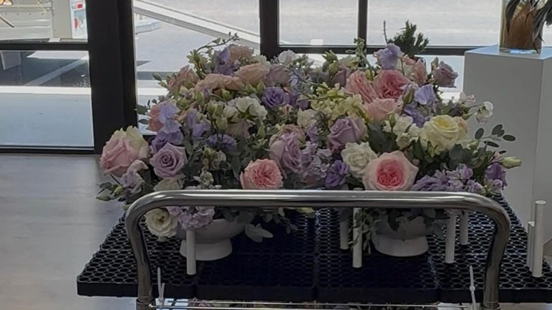 Two carts filled with beautiful floral arrangements inside a store.
