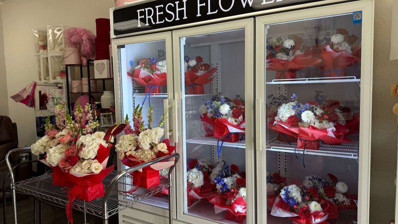 A flower shop cooler filled with fresh flower arrangements.