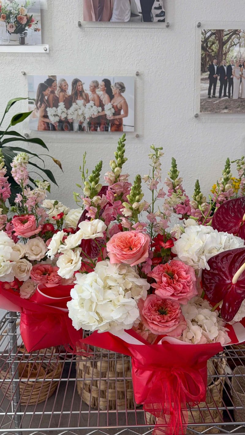 A vibrant floral arrangement with pink and white flowers, accented by red.