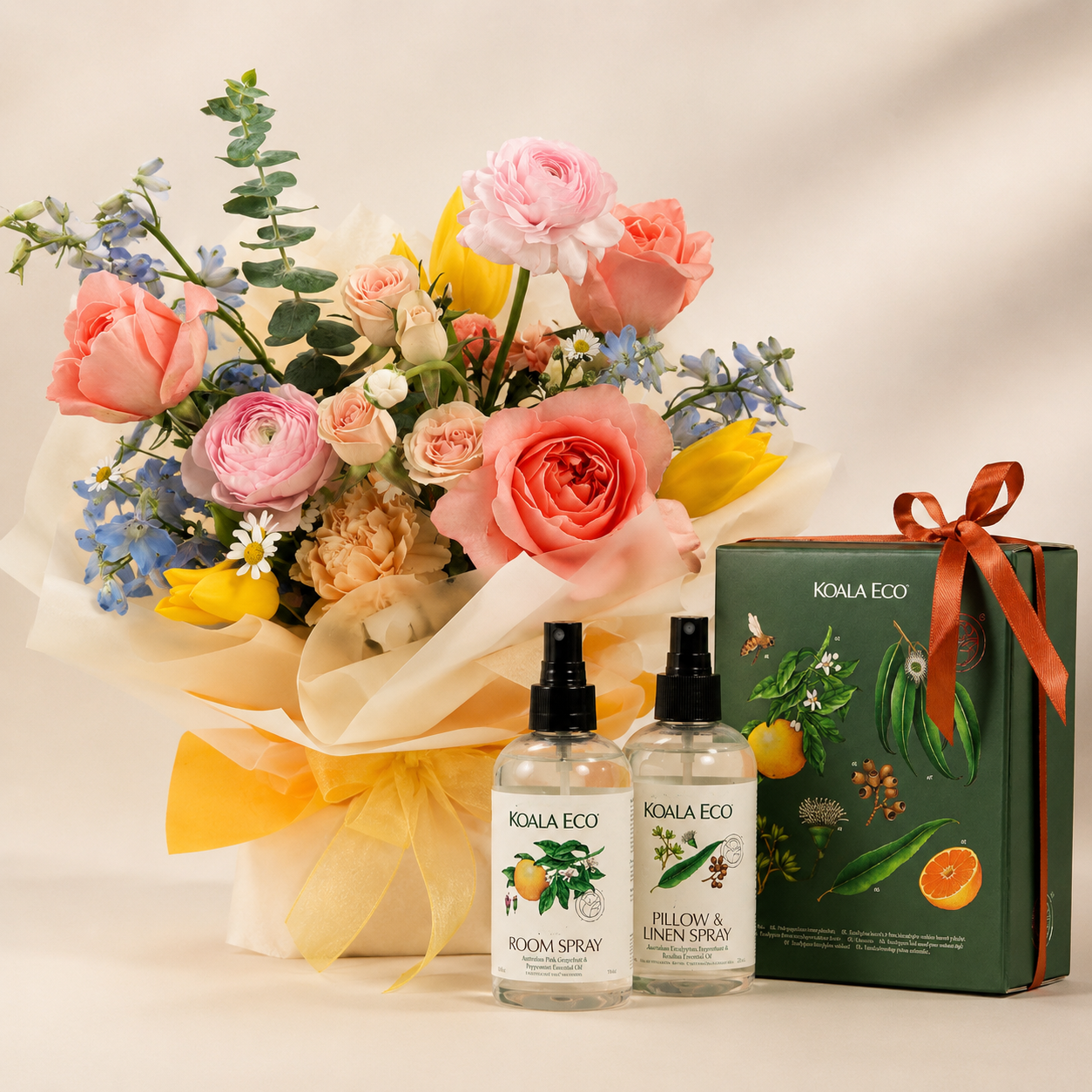 Bouquet of flowers, two bottles of KOALA ECO products, and a gift box on a light background