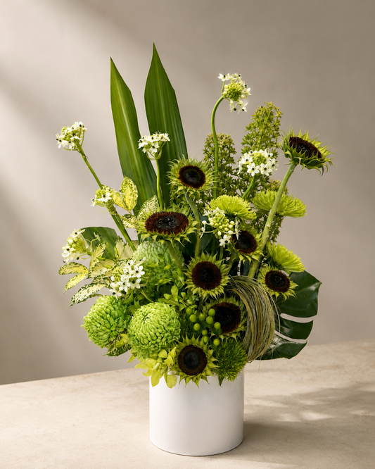 Green Botanical Arrangement in White Vase