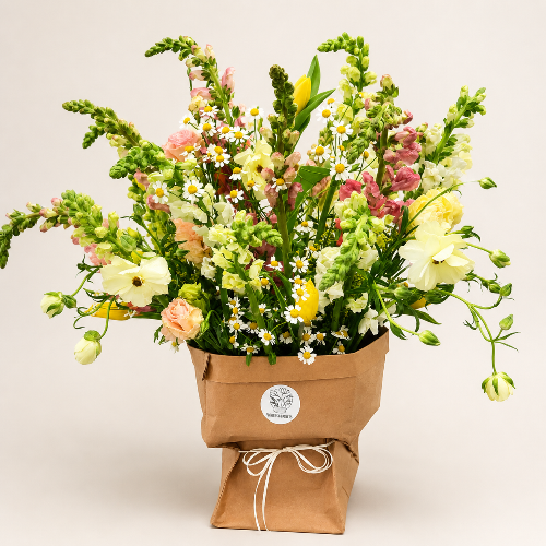 Bouquet of flowers in a brown paper bag on a light background