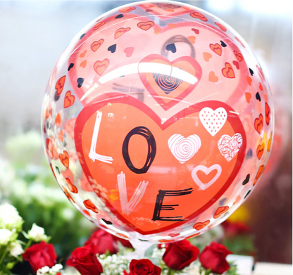 Decorative balloon with heart patterns and 'LOVE' text, surrounded by flowers.