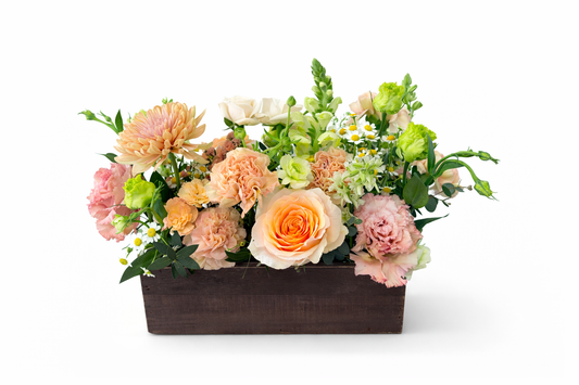 Floral arrangement in a brown rectangular container on a white background