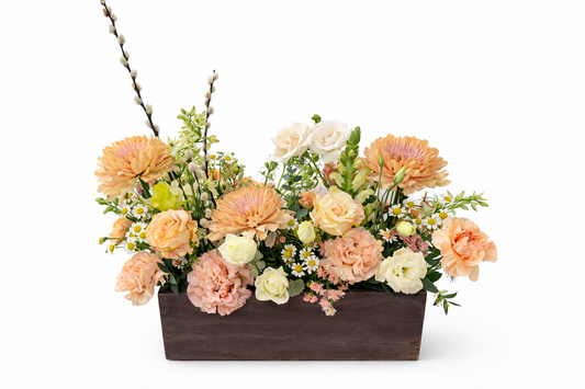 Floral arrangement in a wooden box on a white background