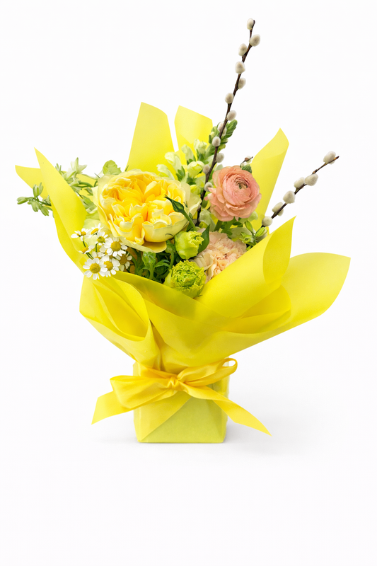 Bouquet of flowers wrapped in yellow paper with a yellow bow 
