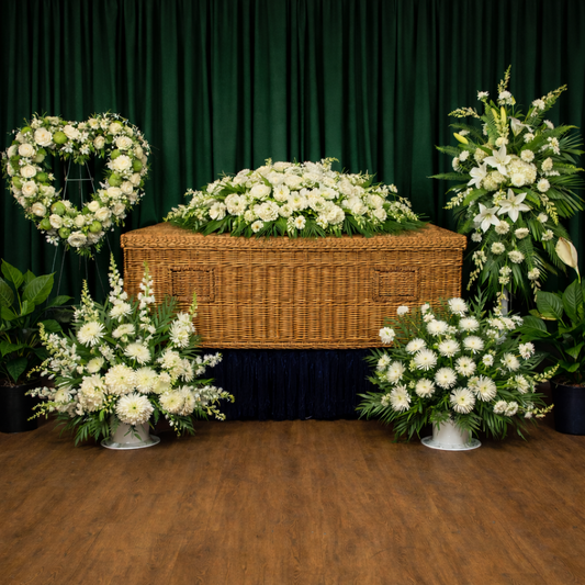 Casket with white flowers and floral arrangements 