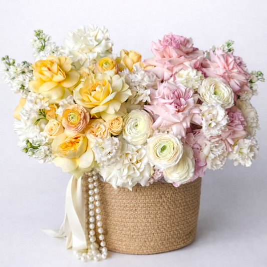 Floral arrangement in a woven basket on a white background