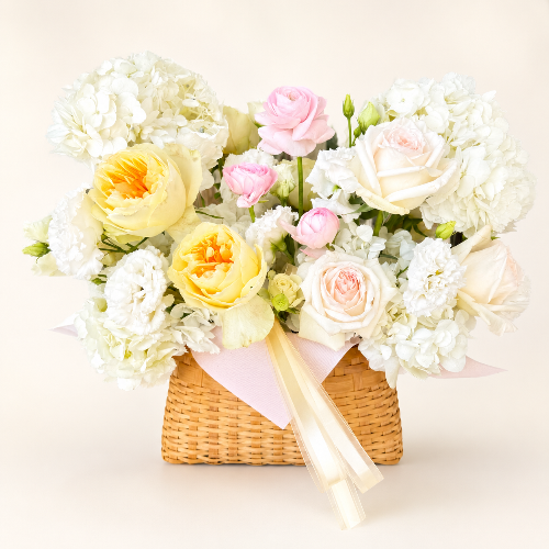 Bouquet of flowers in a woven basket on a light background