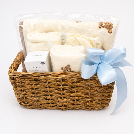 Baby gift basket with blankets, a box, and a blue ribbon on a white background