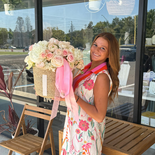 Woman holding a large floral arrangement 