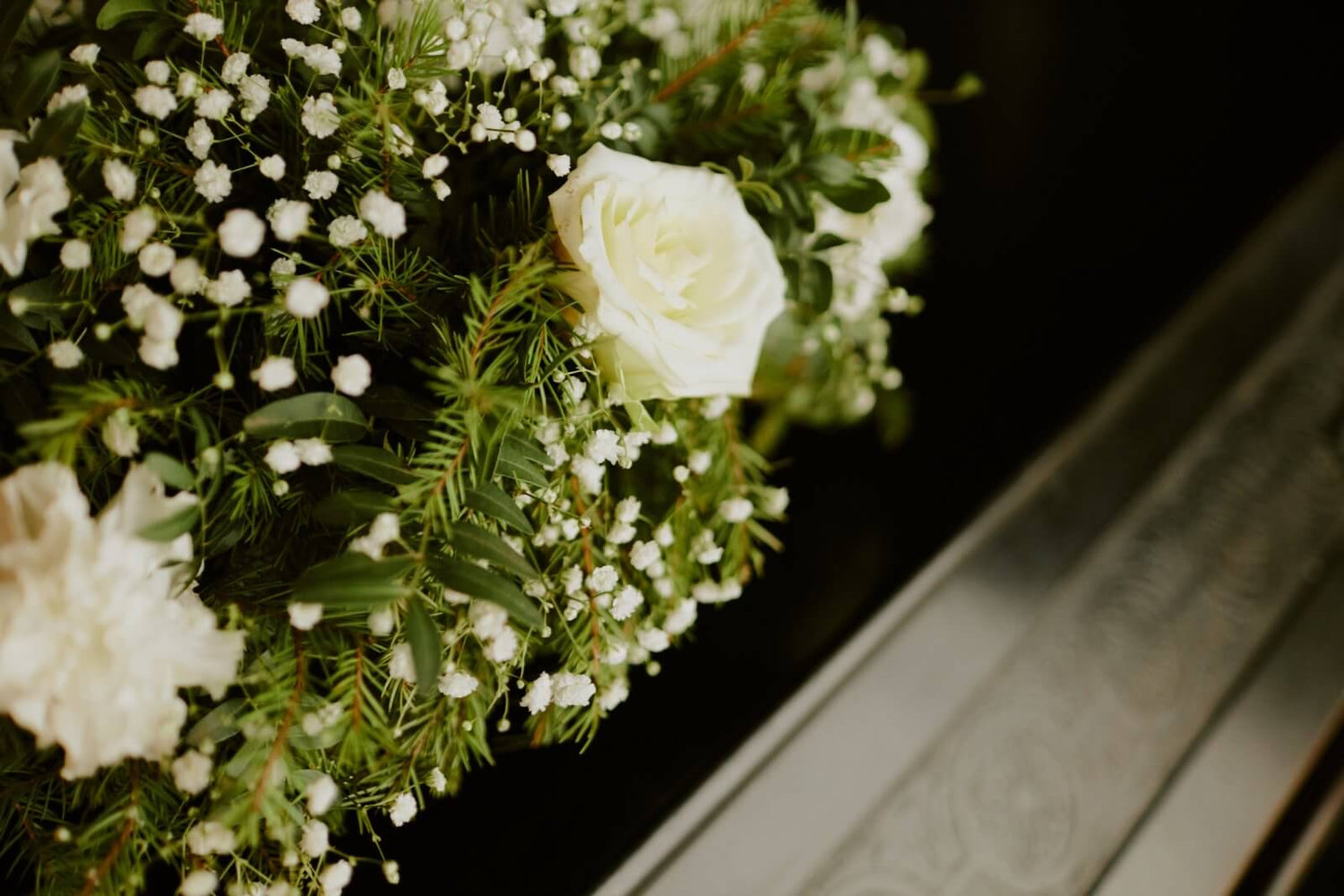 Bouquet of white roses and greenery on a dark background